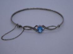 Contemporary 9ct white gold bracelet with central blue topaz, flanked with diamond chip, safety chai