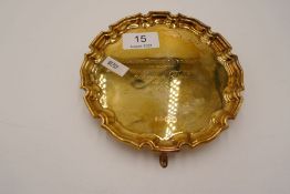 A silver gilt tray of circular form standing on three feet. Decorative, raised border. Engraved on t