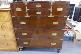 A military style chest of drawers in two parts having side handle and brass decoration, 104cms