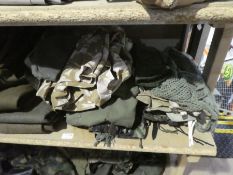 A quantity of Army uniforms to include Battle dress, Rucksacks, Boots etc, 2 shelves