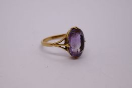 18ct yellow gold dress ring set with large oval cut amethyst on 4 claw mount AF, marked 18ct, size O