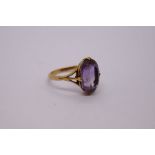 18ct yellow gold dress ring set with large oval cut amethyst on 4 claw mount AF, marked 18ct, size O