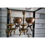 A pair of brass candlesticks and a pair of eastern bowels on wooden stands
