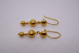 Pair of 18cft yellow drop earrings hung two graduating balls, marked 750, approx 2.7g