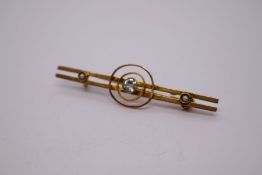 Yellow gold twin-bar brooch, with central blue stone, with a seed pearl to each end