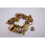 9ct yellow gold charm bracelet 29 charms, to include Go-cart, Articulated Woodpecker, Church, Koala,