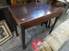 A repro mahogany fold over card table on squared moulded legs