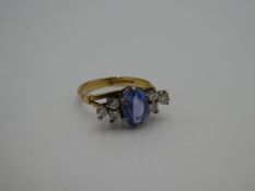 18ct yellow gold seven stone ring set with central oval faceted pale blue sapphire, 9mm x 6mm with t