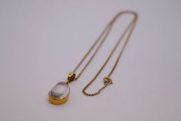 9ct yellow gold neckchain, marked 375, hung with a pendant of a pear shaped moonstone in 14ct gold m