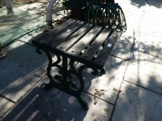 A small garden table having metal ends with teak slats
