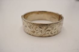 A silver heavy bangle engraved with stylised foliate scroll design. Hallmarked London 1965 Georg Jen