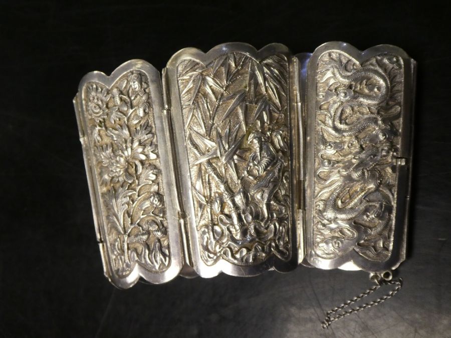 Chinese articulated silver cuff, 6 embossed panels decorated figures, building, dragons and flowers,
