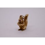 A 9ct yellow gold figural squirrel and charm inset with ruby eyes, marked GJ Ltd, 375, approx 1.5cm.