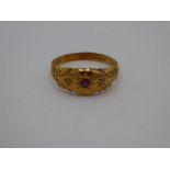 18ct yellow gold gypsy ring with central starburst set ruby and two small diamond chips, marked 18,