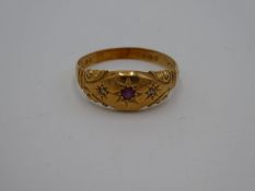 18ct yellow gold gypsy ring with central starburst set ruby and two small diamond chips, marked 18,