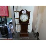 A mantle clock in the form of a longcase clock and a wooden cased wall clock