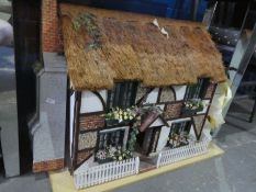 A modern dolls house in the form of a thatched cottage, plus one other dolls house