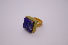 Decorative high carat gold continental ring with square blue hardstone above green enamelled step ov