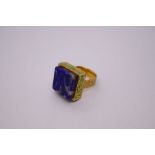 Decorative high carat gold continental ring with square blue hardstone above green enamelled step ov