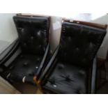 A pair of 1970s armchairs having faux black leather upholstery