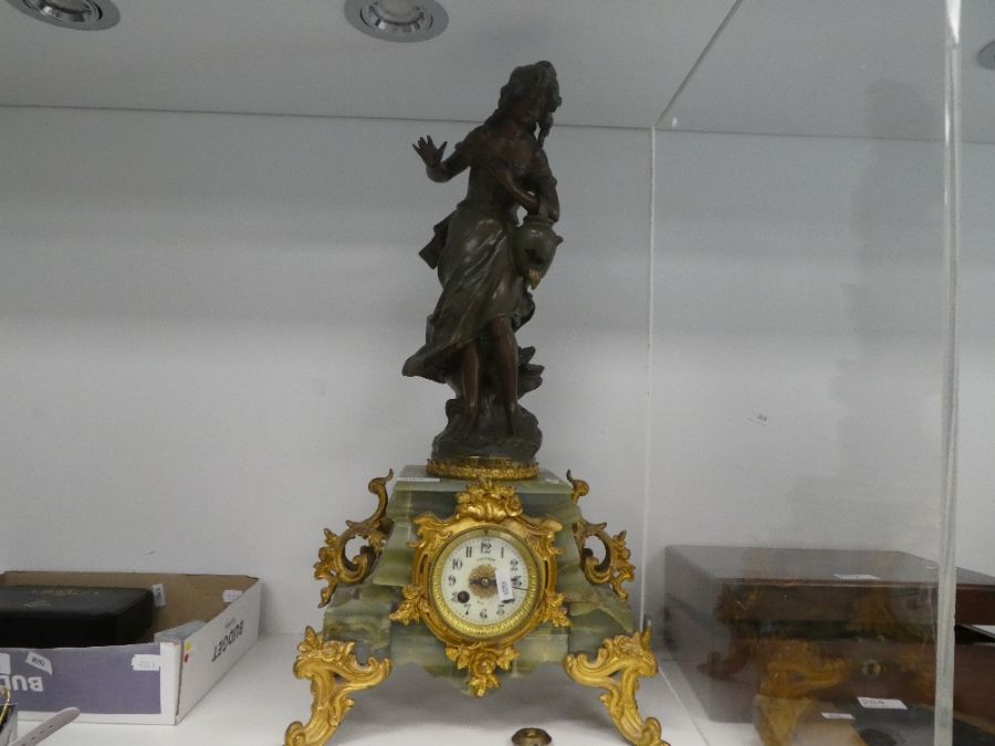 An antique French figural clock having spelter lady holding bucket with gilt metal and onyx base, 62