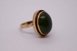 Continental yellow gold ring with large oval cabouchon green hardstone. WWJ, European hallmark, size