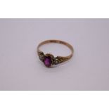 Antique 10ct yellow gold ring with central amethyst with a seed pearl to either side on engraved sho