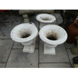 A set of four Victorian cast iron garden urns on square base, two detached from bases, 50cm high