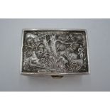 A silver snuff box having decorative embossed design lid of trees and a hunting scene. Gilt interior
