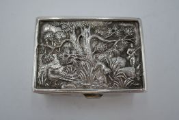 A silver snuff box having decorative embossed design lid of trees and a hunting scene. Gilt interior