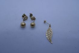 Pair of yellow metal drop earrings each hung with about a single 9ct leaf earring