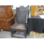 An antique Wainscot style chair probably from the period having carved back and frieze