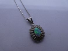 Modern 18ct white gold fine neckchain hung with 18K flower head pendant with central blue/green opal