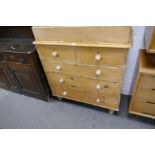 An old stripped pine chest, having 3 long and 2 short drawers on turned feet, 99cm