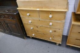 An old stripped pine chest, having 3 long and 2 short drawers on turned feet, 99cm