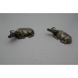 Two possibly Chinese silver water buffalo at rest, having indistinct character marks on the bases. M