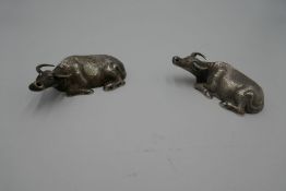 Two possibly Chinese silver water buffalo at rest, having indistinct character marks on the bases. M