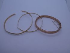 Three 9ct yellow gold bangles; two AF, cut examples, both marked 375, and a 9ct Rose gold bangle wit