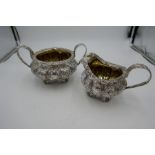 A very ornate Georgian heavily decorated large silver sugar bowl and milk jug having silver gilt int