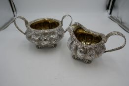 A very ornate Georgian heavily decorated large silver sugar bowl and milk jug having silver gilt int