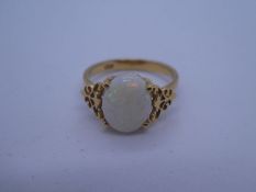18ct yellow gold dress ring with central oval white opal on decorative floral shoulders, marked 18K,