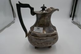 A large silver teapot of fluted baluster form. Floreated gadroon border rim, girdle body on four bal