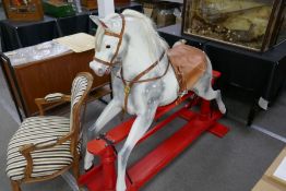 A Victorian style dappled grey rocking horse on red painted base, 175cm approx
