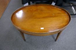 A reproduction mahogany oval coffee table on square legs, 92cm