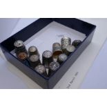 A quantity of silver and metal thimbles with various ornate, embossed design, and hallmarks to inclu