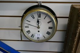An old ships bulkhead clock having brass bezzle with black painted surround