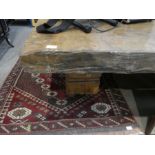 A large oblong coffee table having thick Walnut too, roughly cut on 2 square pedestal supports