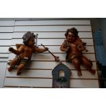 A pair of resin Cupids, playing musical instruments