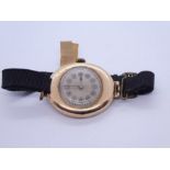 Antique 9ct yellow gold cased oval shaped watch on black fabric strap, case marked 375, 19.3g gross