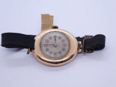 Antique 9ct yellow gold cased oval shaped watch on black fabric strap, case marked 375, 19.3g gross